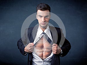 Businessman tearing off shirt and showing mucular body