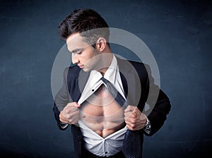 Businessman tearing off shirt and showing mucular body