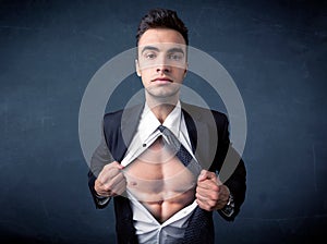 Businessman tearing off shirt and showing mucular body