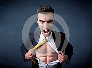 Businessman tearing off shirt and showing mucular body