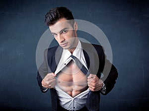 Businessman tearing off shirt and showing mucular body