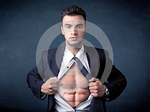 Businessman tearing off shirt and showing mucular body