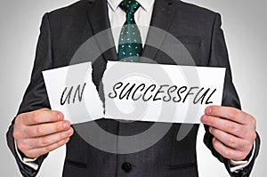 Businessman tearing paper with unsuccessful word