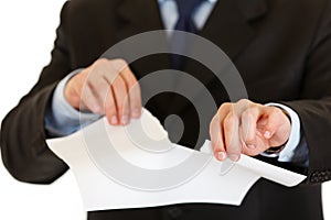 Businessman tearing sheet of white paper. Closeup