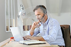 Businessman teleworking on laptop photo