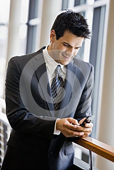 Businessman text messaging on cell phone