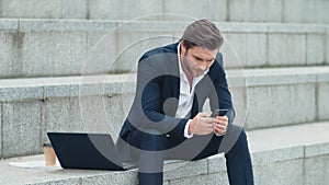 Businessman texting on cellphone at street. Professional working on smartphone