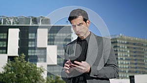 Businessman texting on cellphone at street. Professional working on smartphone