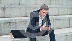 Businessman texting on cellphone at street. Professional working on smartphone