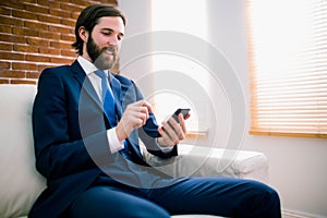 Businessman texting on the couch