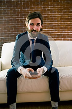 Businessman texting on the couch