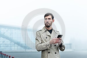 Businessman texting messages while walking. Young businessman typing text message on his way to work