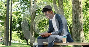 Businessman texting using mobile phone at city park