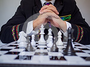 Businessman thinking for moving chess piece on board with white background, challenges planning business strategy to success