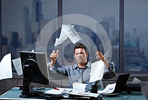 Businessman throwing documents into air