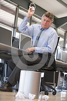 Businessman throwing paper into bin