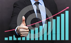 Businessman with thumb up gesture and business graph