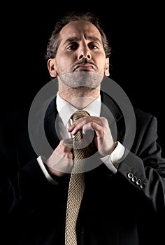Businessman tie fastening, overwhelmed expression
