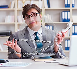 Businessman tied with chains to his work