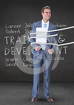 Businessman tied up with rope and paper against text in background