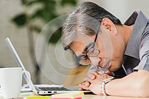 Businessman tired overworked he sleeping over a laptop computer