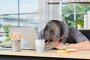 Businessman tired overworked he sleeping over a laptop computer