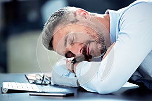 Businessman, tired and sleeping with desk in office with exhausted from overworked in company. Corporate, closeup and
