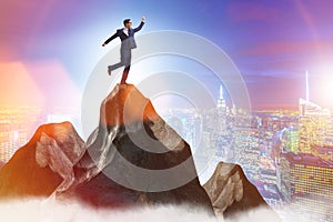 Businessman at the top of mountain in career concept