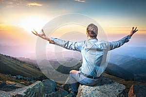 Businessman at the top of the mountain sitting and thinking