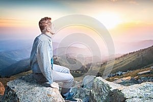 Businessman at the top of the mountain sitting and thinking