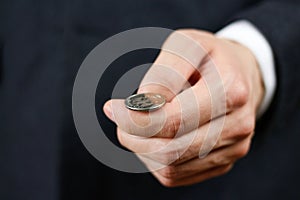 Businessman tossing a coin. Heads or tails. Close up