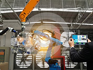 Businessman touch screen control robot the production of factory parts engine manufacturing industry robots