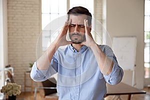 Businessman touches head closed eyes feels unhealthy suffers from headache