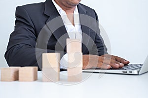 Businessman touches the woodblocks placed on the  table