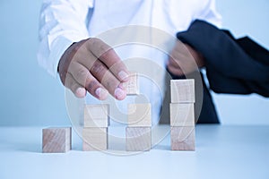 Businessman touches the woodblocks placed on the  table