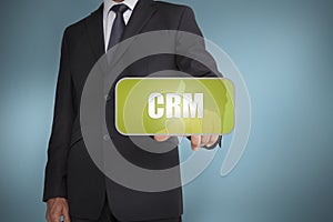 Businessman touching green tag with the word crm written on it