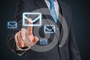 Businessman is touching mail symbol with finger on futuristic screen