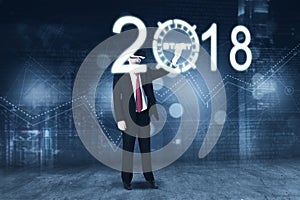 Businessman touching a start button with numbers 2018