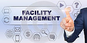 Businessman touching virtual screen with his finger. Screen caption - FACILITY MANAGEMENT photo