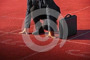 A businessman on a track ready for race in business