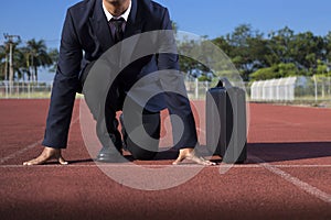 A businessman on a track ready for race in business