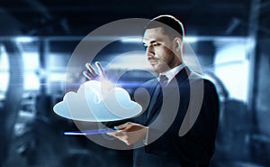 Businessman with transparent tablet and cloud