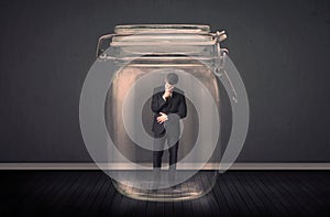 Businessman trapped into a glass jar concept