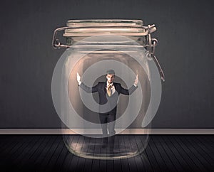 Businessman trapped into a glass jar concept