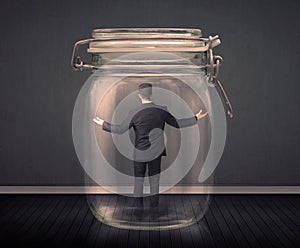 Businessman trapped into a glass jar concept