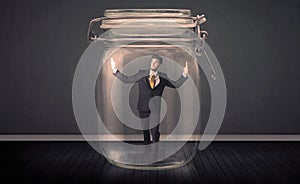 Businessman trapped into a glass jar concept