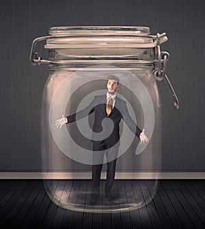 Businessman trapped into a glass jar concept