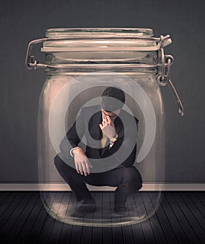 Businessman trapped into a glass jar concept