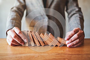 A businessman try to holding wooden block while falling for business concept