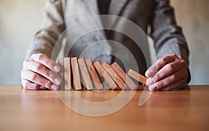 A businessman try to holding wooden block while falling for business concept